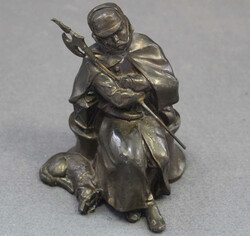 DER SCHLAFENDE NACHTWÄCHTER: sitzende Bronzefigur im Mantel mit ...
