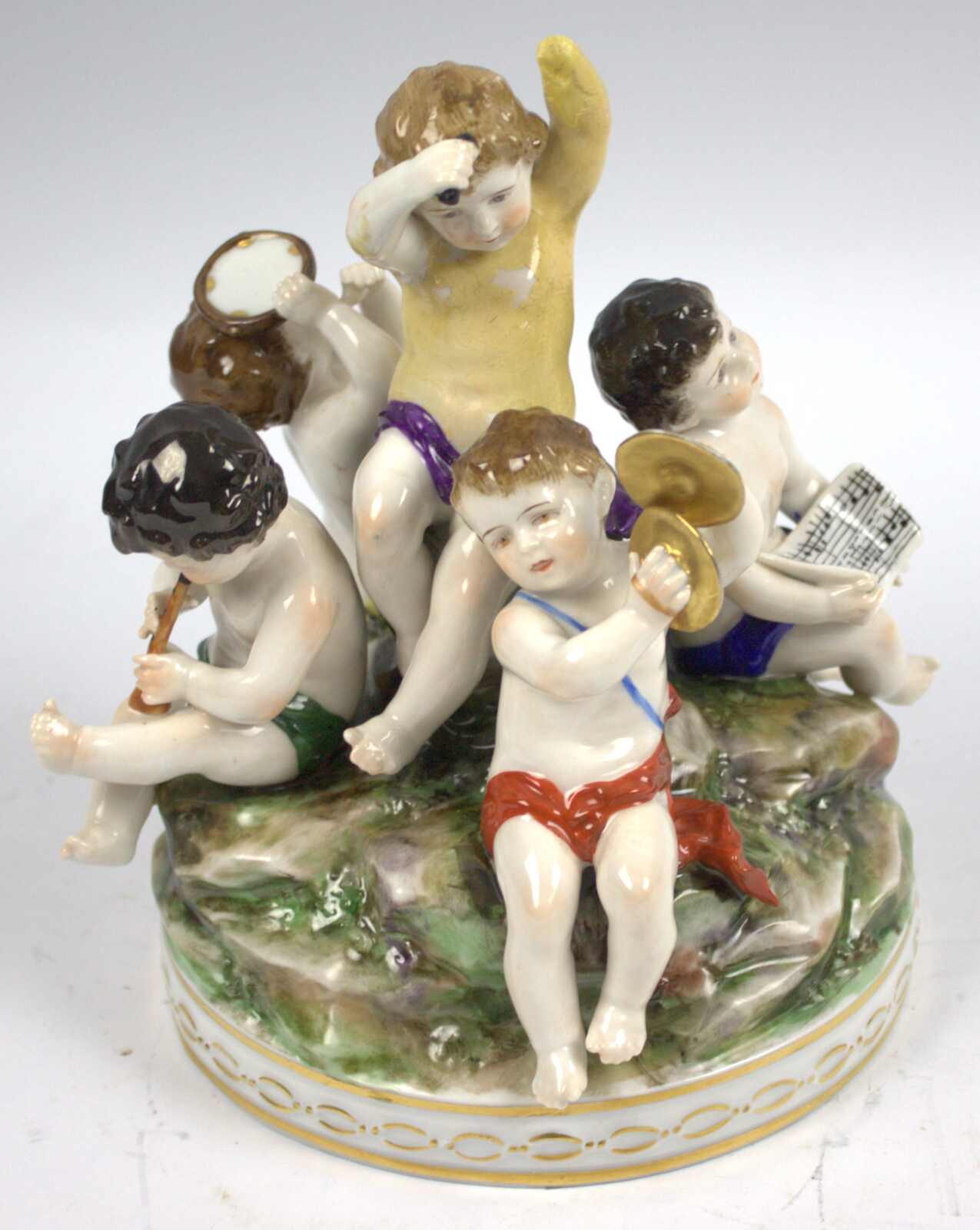 Porzellangruppe musizierender Putti. Auf rundem Natur-Sockel ...