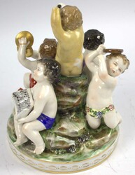 Porzellangruppe musizierender Putti. Auf rundem Natur-Sockel ...