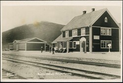 BJORLI Station, Raumabanen. Nærbilde hovedbygget og noe folk rundt ...